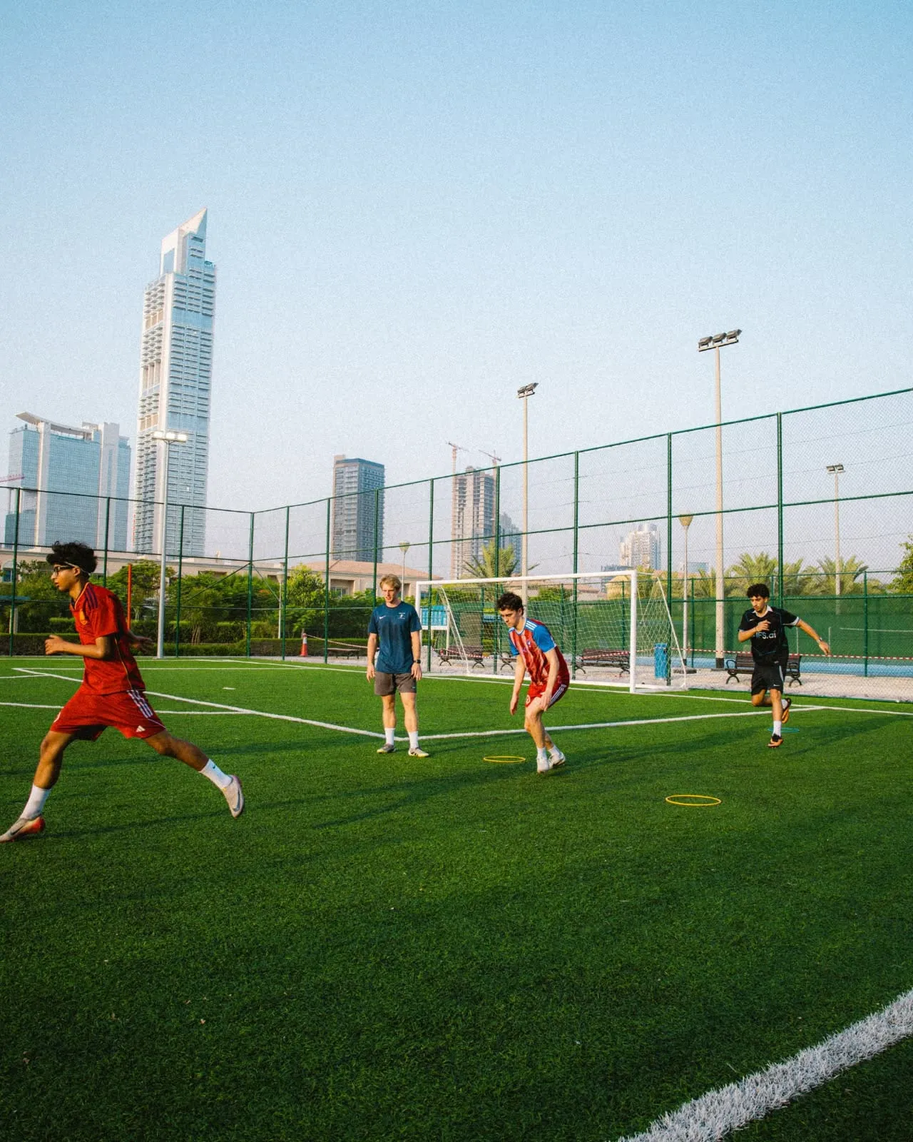 A small-group Hulley Performance session on a pitch in Dubai at dusk