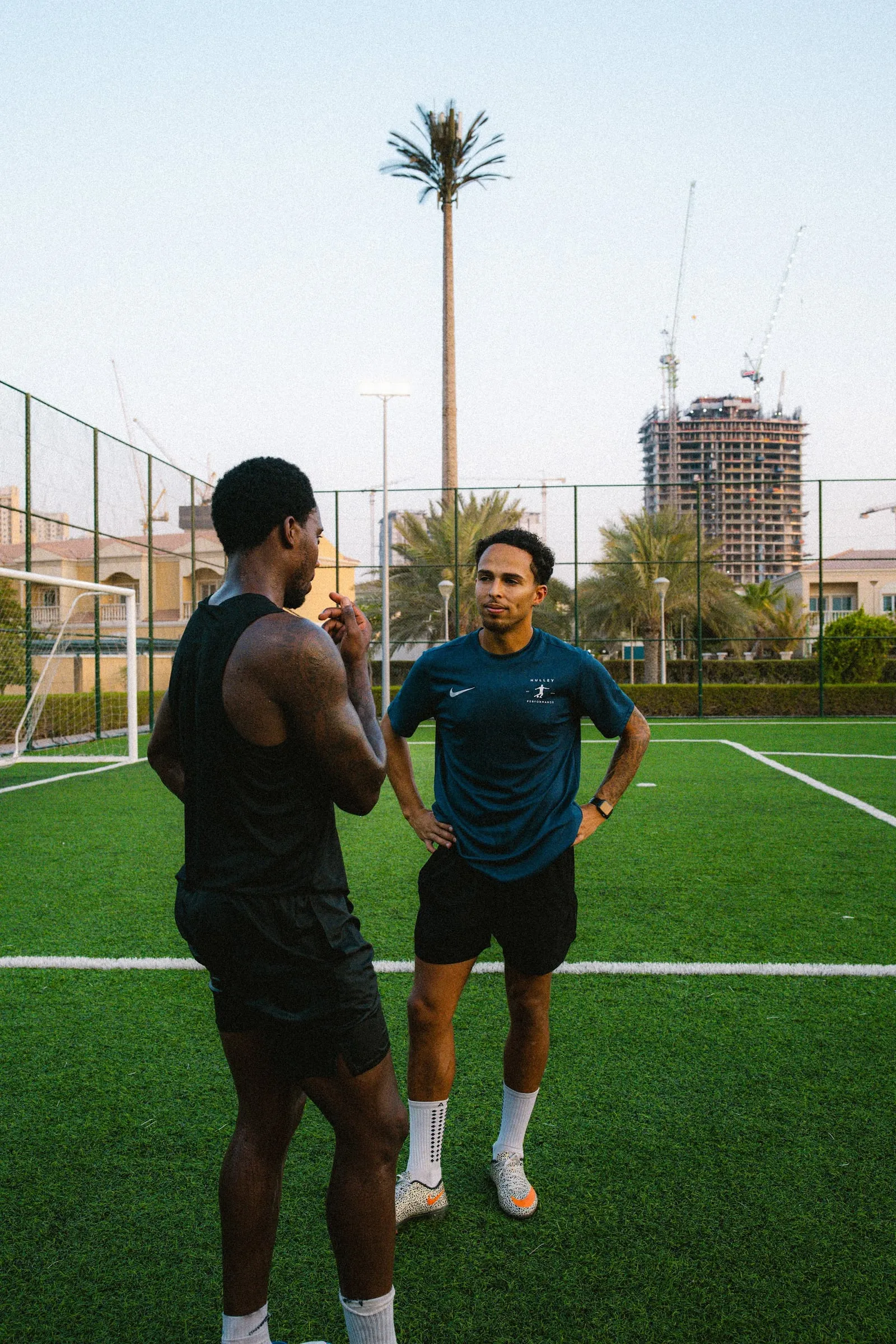 A Hulley Performance coach talking one-to-one with a player on a Dubai pitch